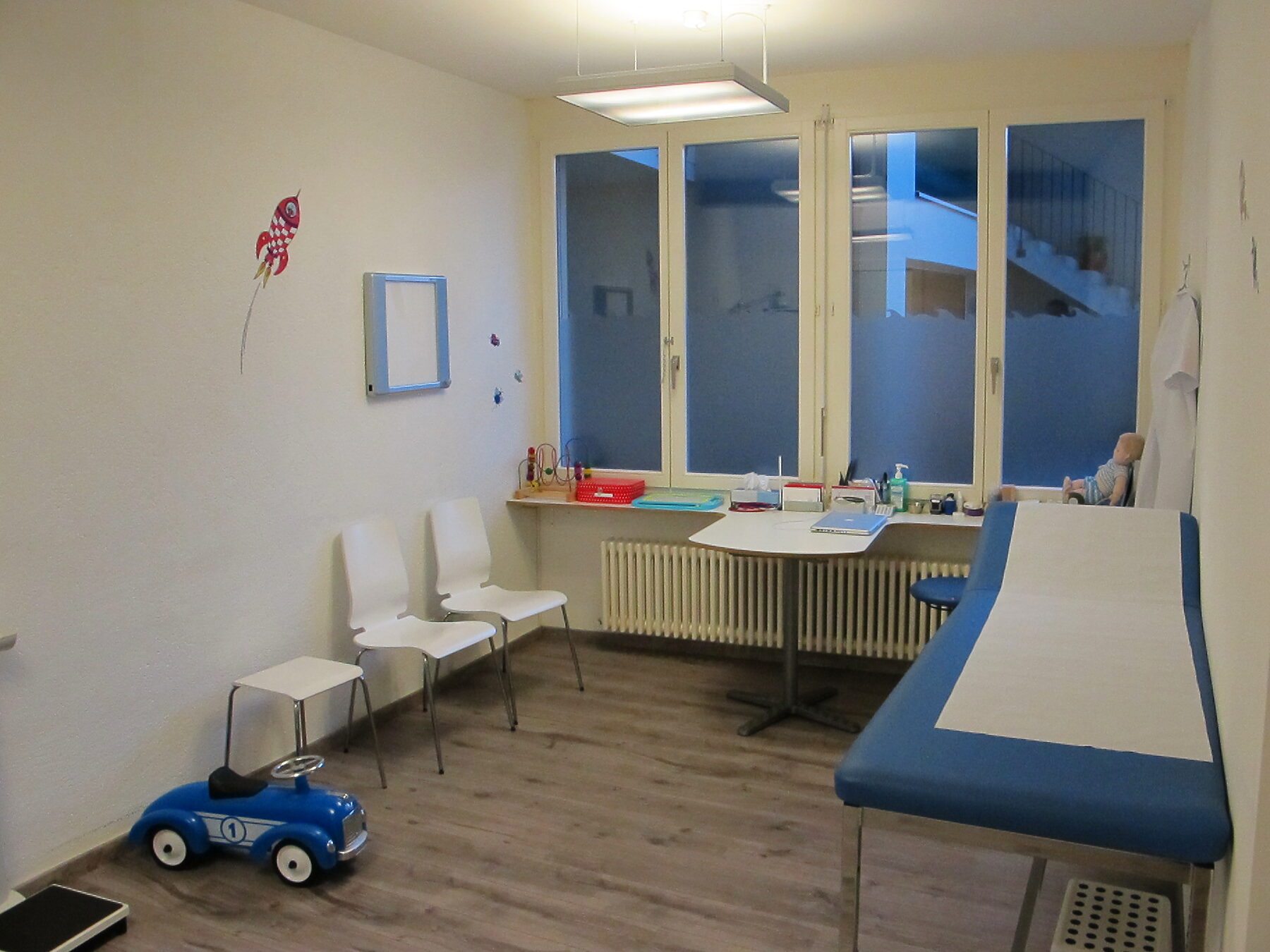 Une salle de consultation avec sa table d’examen et ses grandes fenêtres